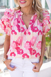 Top floral rosa con cuello abierto, mangas abullonadas y volantes