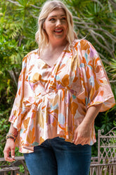 Orangefarbene Bluse mit V-Ausschnitt und Schößchen in Übergröße mit Blumenmuster