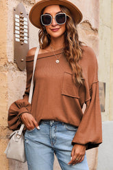 Orangefarbener, lockerer Pullover mit aufgesetzter Tasche und sichtbaren Nähten