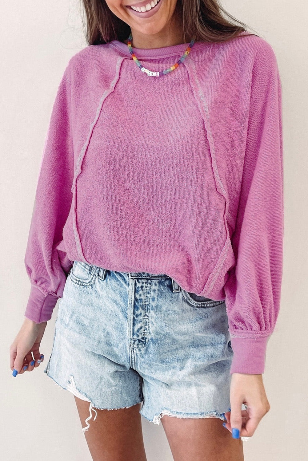 Jersey de rizo rosa con cuello redondo y costuras expuestas