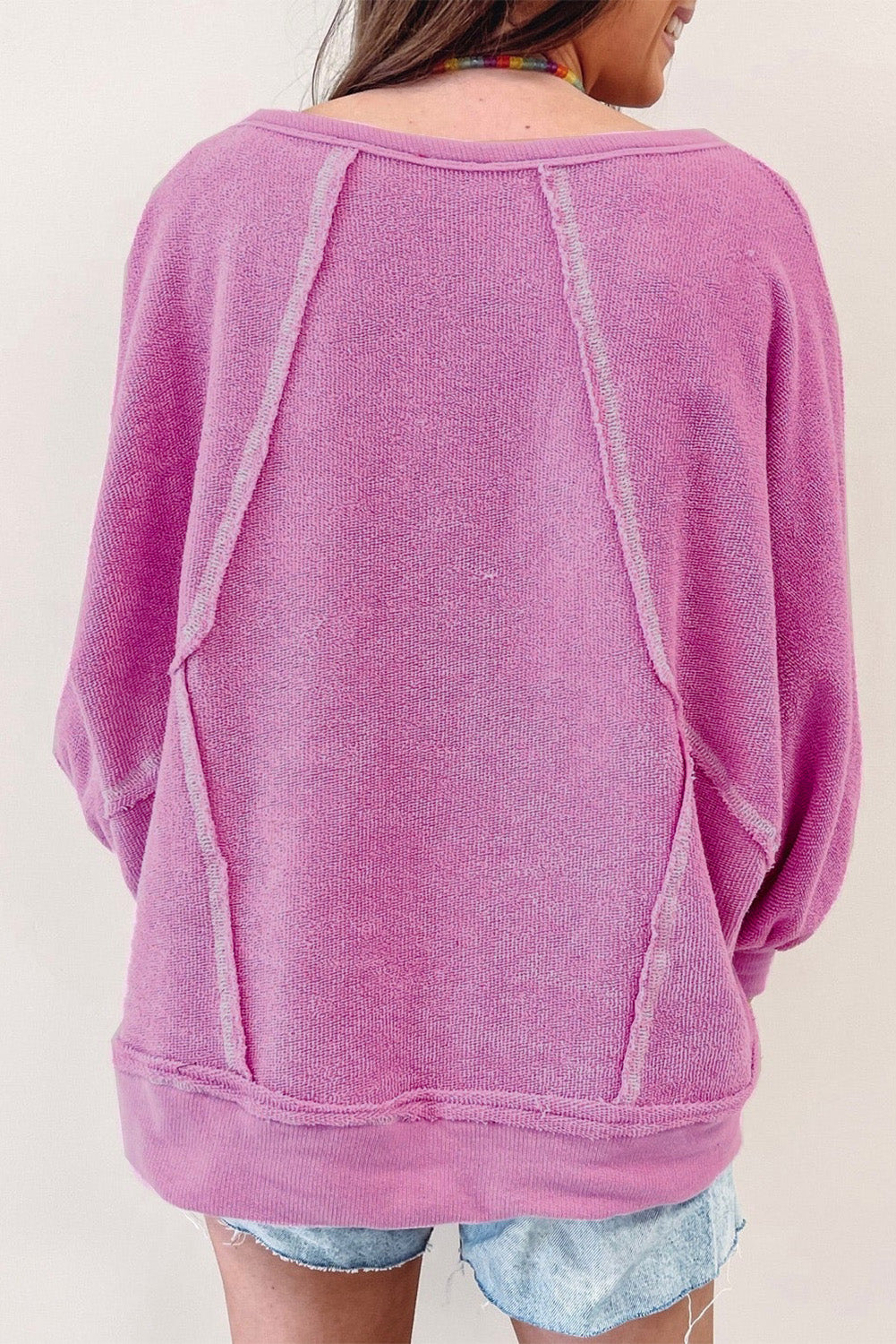Jersey de rizo rosa con cuello redondo y costuras expuestas